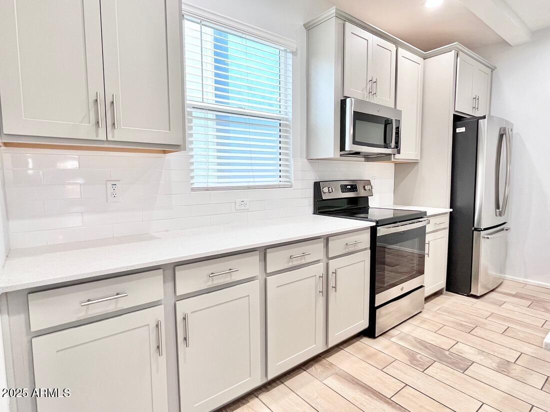 3434 North Longview Avenue, Unit 13 Phoenix, AZ 85014 - Photo 7 of 53 a kitchen with white cabinets stainless steel appliances and sink