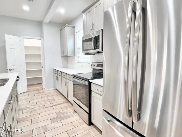 a kitchen with stainless steel appliances a refrigerator and a stove top oven
