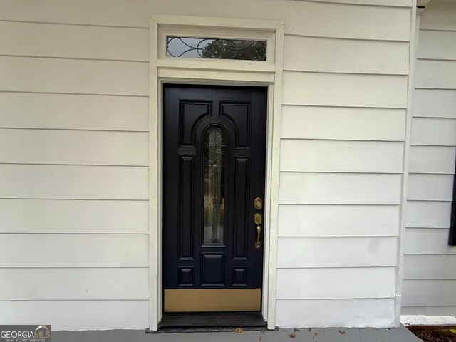 an empty room with wooden floor fireplace and windows