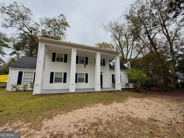 a view of a white house with large windows