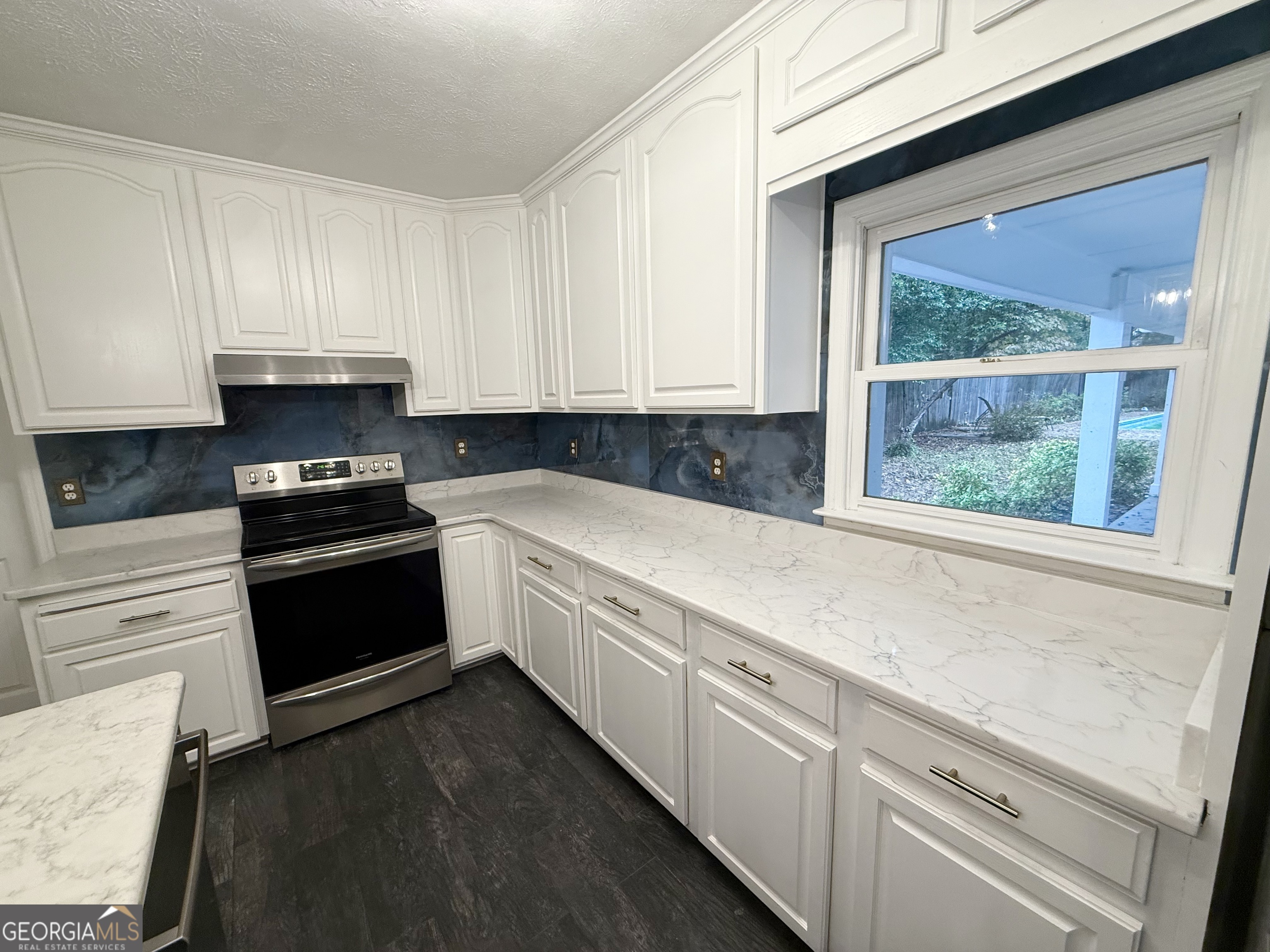 209 Mimosa Drive Dublin, GA 31021 - Photo 41 of 68 a kitchen with granite countertop a sink and white cabinets