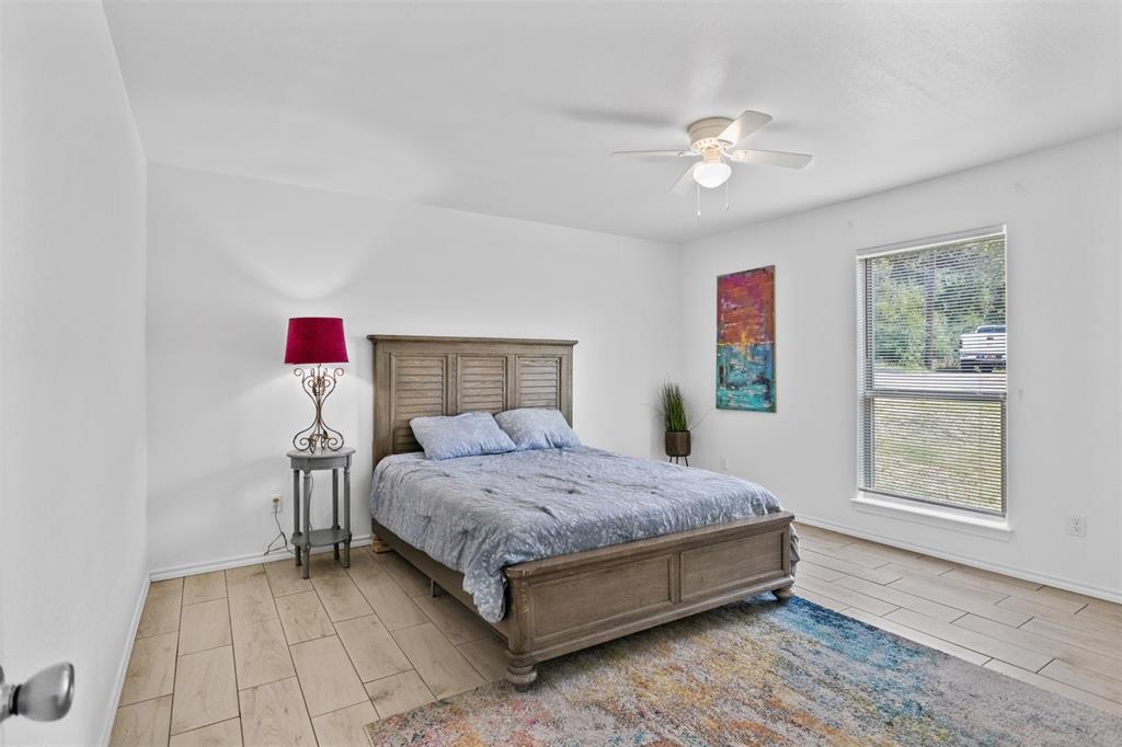 1816 Hidden Valley Road Granbury, TX 76049 - Photo 15 of 23 a bedroom with a bed and a chandelier