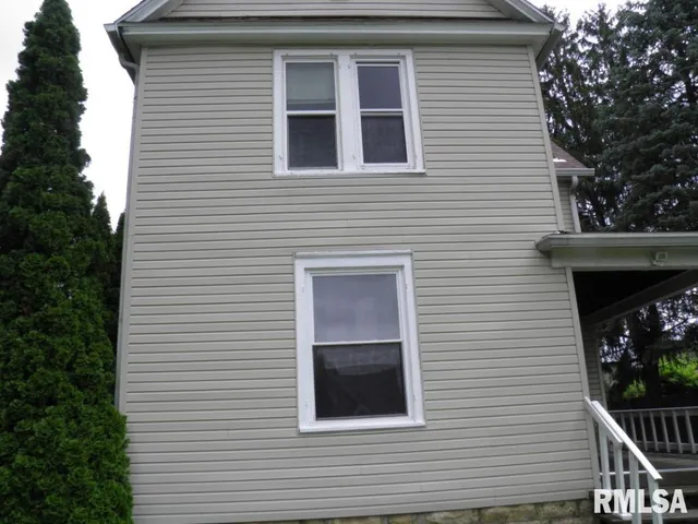 a view of a house with a door and a tree