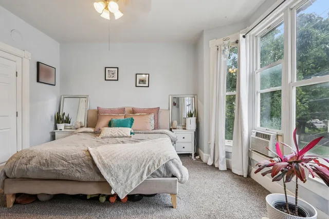 a bedroom with bed and large windows