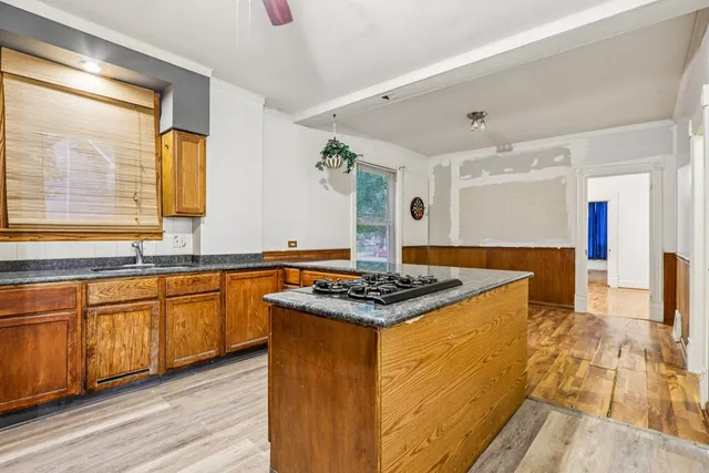 a kitchen with stainless steel appliances granite countertop a stove a sink and a microwave