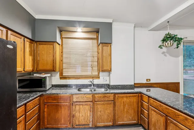 a view of a kitchen with a sink hardwood floor and a large window