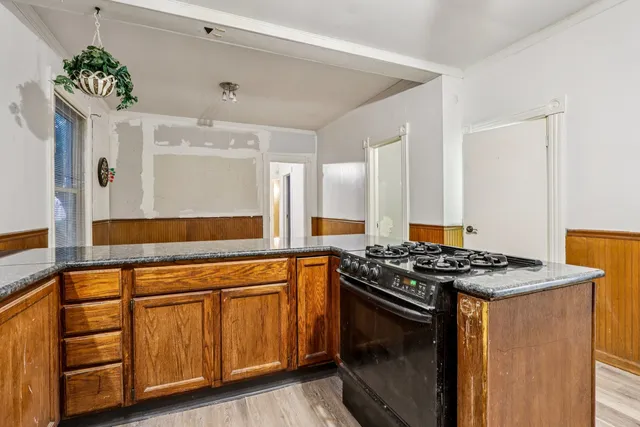 a kitchen with stainless steel appliances kitchen island granite countertop a refrigerator and a sink