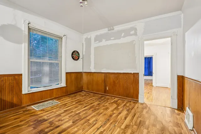wooden floor in an empty room with a window