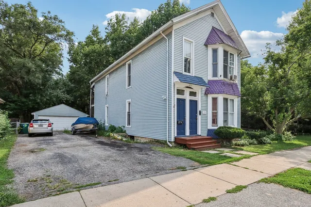 a view of a white house with a yard and plants