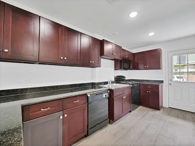 a kitchen with stainless steel appliances granite countertop wooden cabinets a stove top oven and granite counter tops