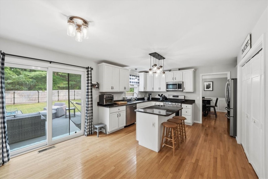 26 Davis Circle Warwick, RI 02886 - Photo 15 of 50 . The spacious dining area easily accommodates a large table, while sliding glass doors provide seamless access to the expansive composite deck and backyard oasis, making indoor-outdoor gatherings a breeze.