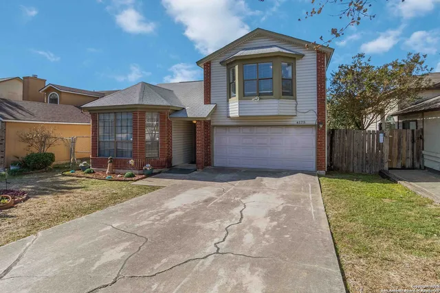 a front view of a house with yard and garage