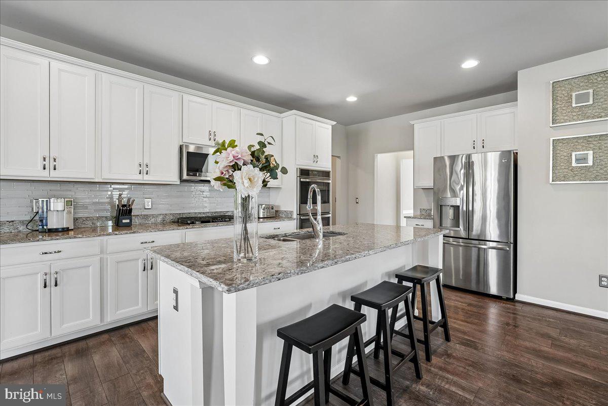 12268 Sedge Street Bristow, VA 20136 - Photo 9 of 48 a kitchen with stainless steel appliances granite countertop white cabinets a sink and dishwasher