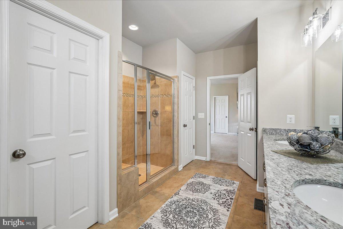 12268 Sedge Street Bristow, VA 20136 - Photo 17 of 48 a bathroom with a granite countertop tub sink and glass door