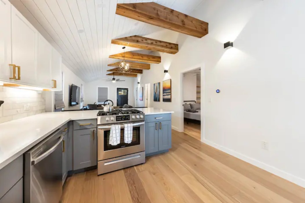 2319 Santa Rita Street Austin, TX 78702 - Photo 26 of 26 Kitchen featuring stainless steel appliances, a peninsula, open floor plan, decorative light fixtures, and light wood finished floors