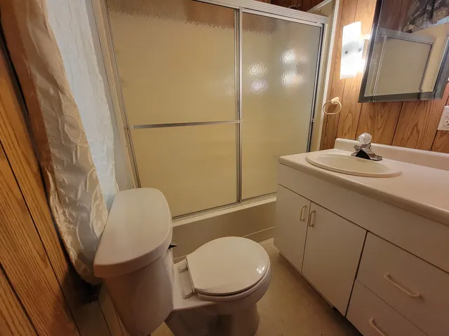 a bathroom with a sink a toilet a mirror and shower