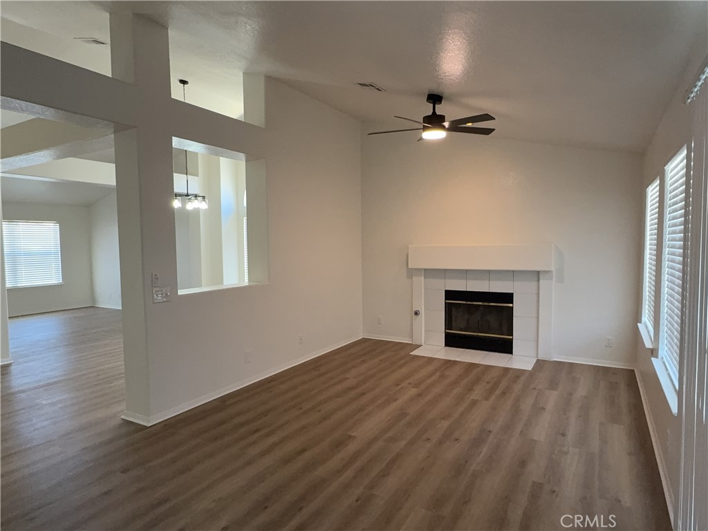12590 Cobalt Road Victorville, CA 92392 - Photo 14 of 37 an empty room with wooden floor fireplace and windows