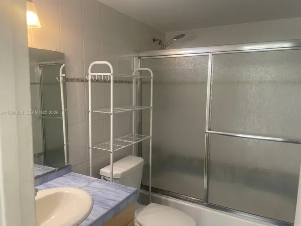 a bathroom with a granite countertop bathtub shower sink and toilet