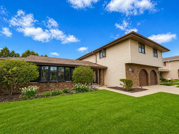 a front view of house with a garden and yard
