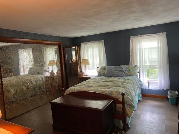 a bedroom with a bed and a large window