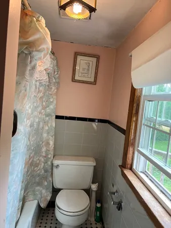 a white toilet sitting next to a shower curtain