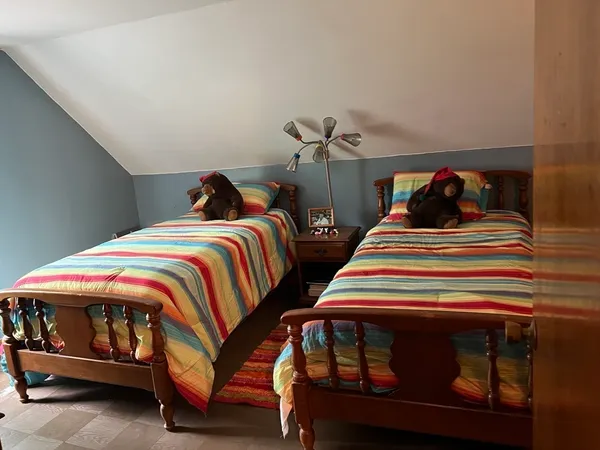 a bedroom with two beds and lamp