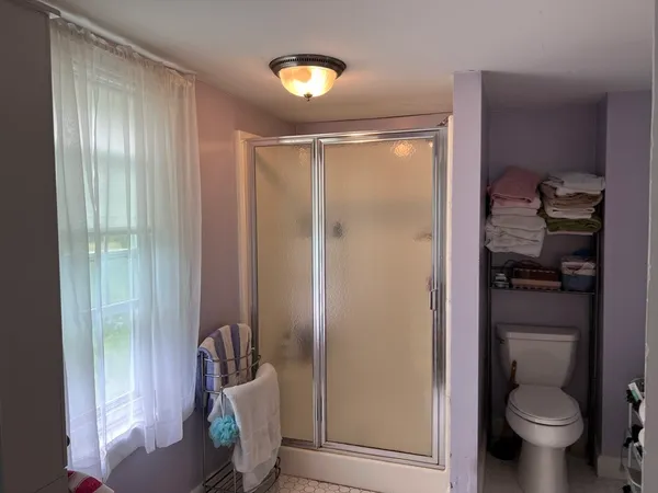 a bathroom with a toilet and a shower