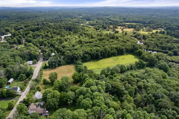 an aerial view of residential houses with outdoor space and trees