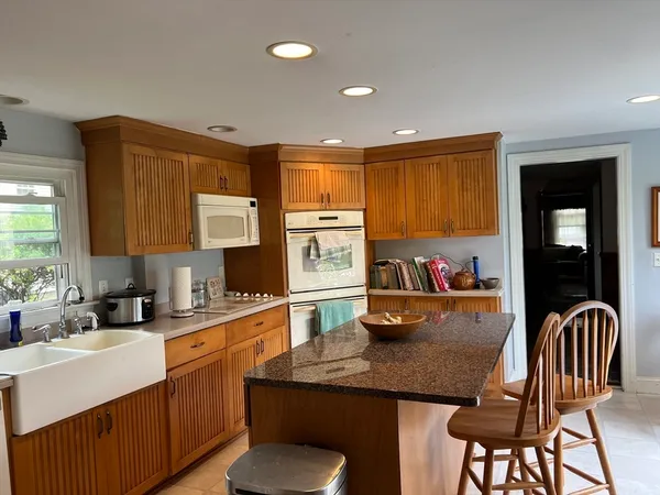 a kitchen with stainless steel appliances granite countertop a stove top oven a sink dishwasher and cabinets with wooden floor