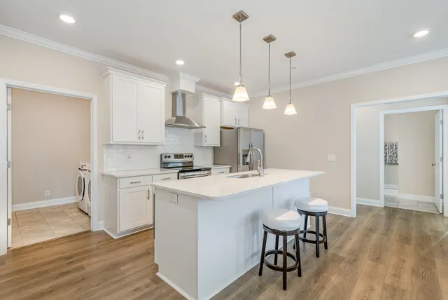 a kitchen with kitchen island a stove a table and chairs
