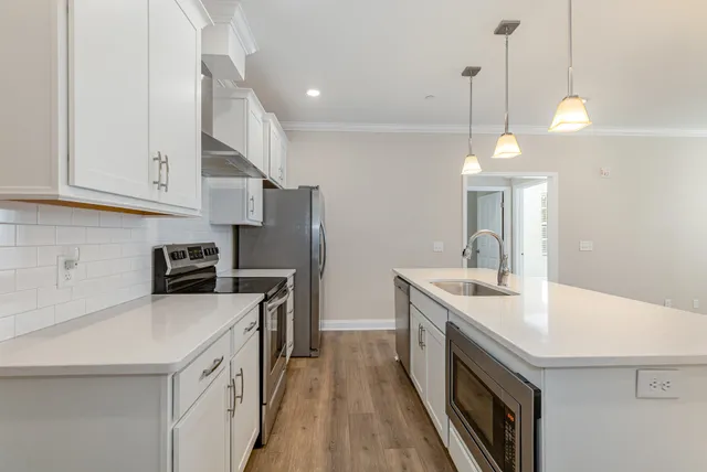 a kitchen with a sink a stove a refrigerator and a center island