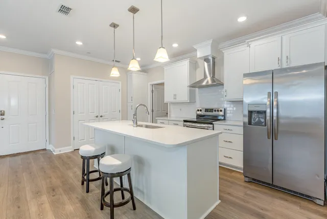 a kitchen with kitchen island a dining table chairs sink and cabinets