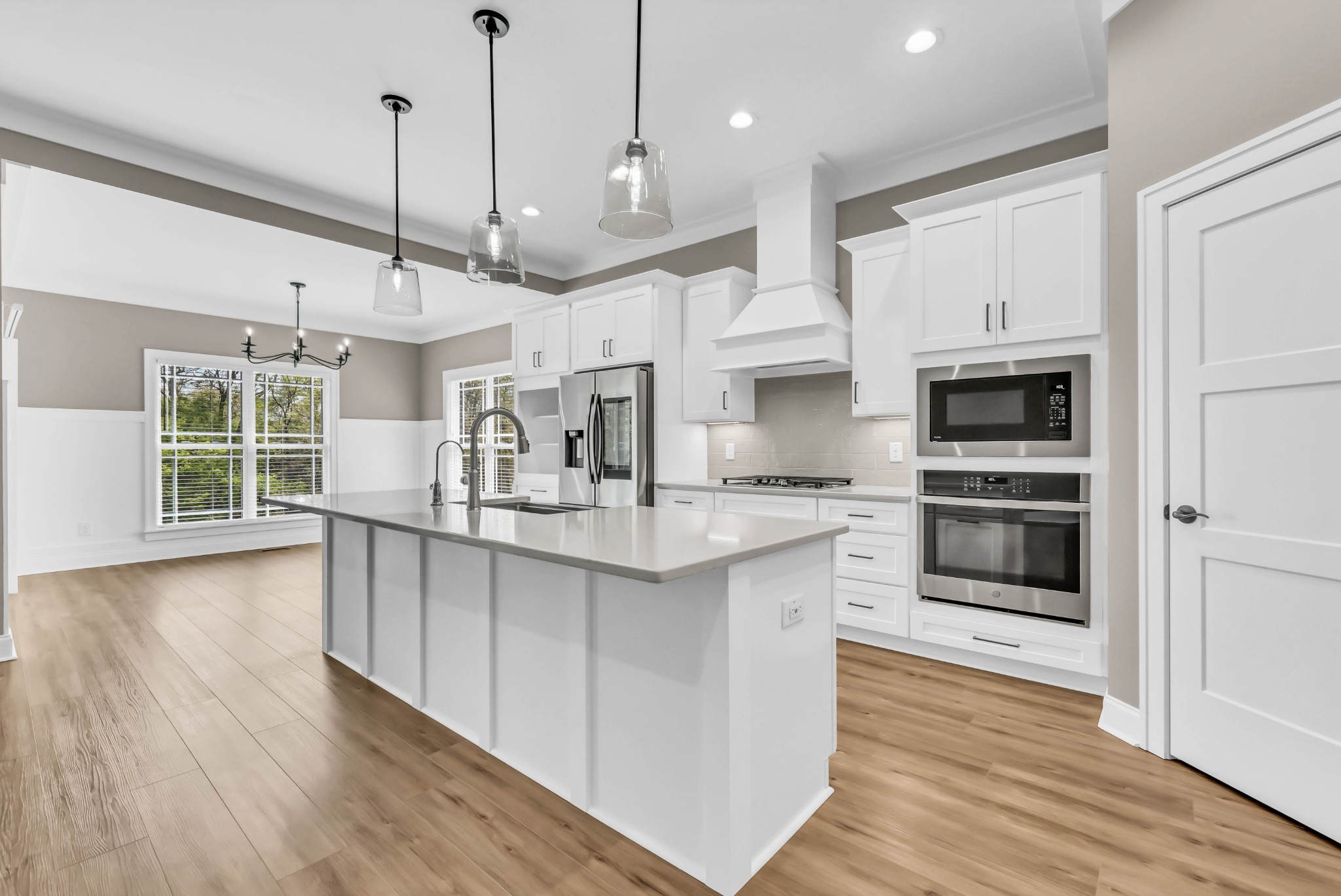 282 Martha Morgan Way Cunningham, TN 37052 - Photo 15 of 36 a kitchen with stainless steel appliances granite countertop a sink a microwave oven a refrigerator and white cabinets with wooden floor