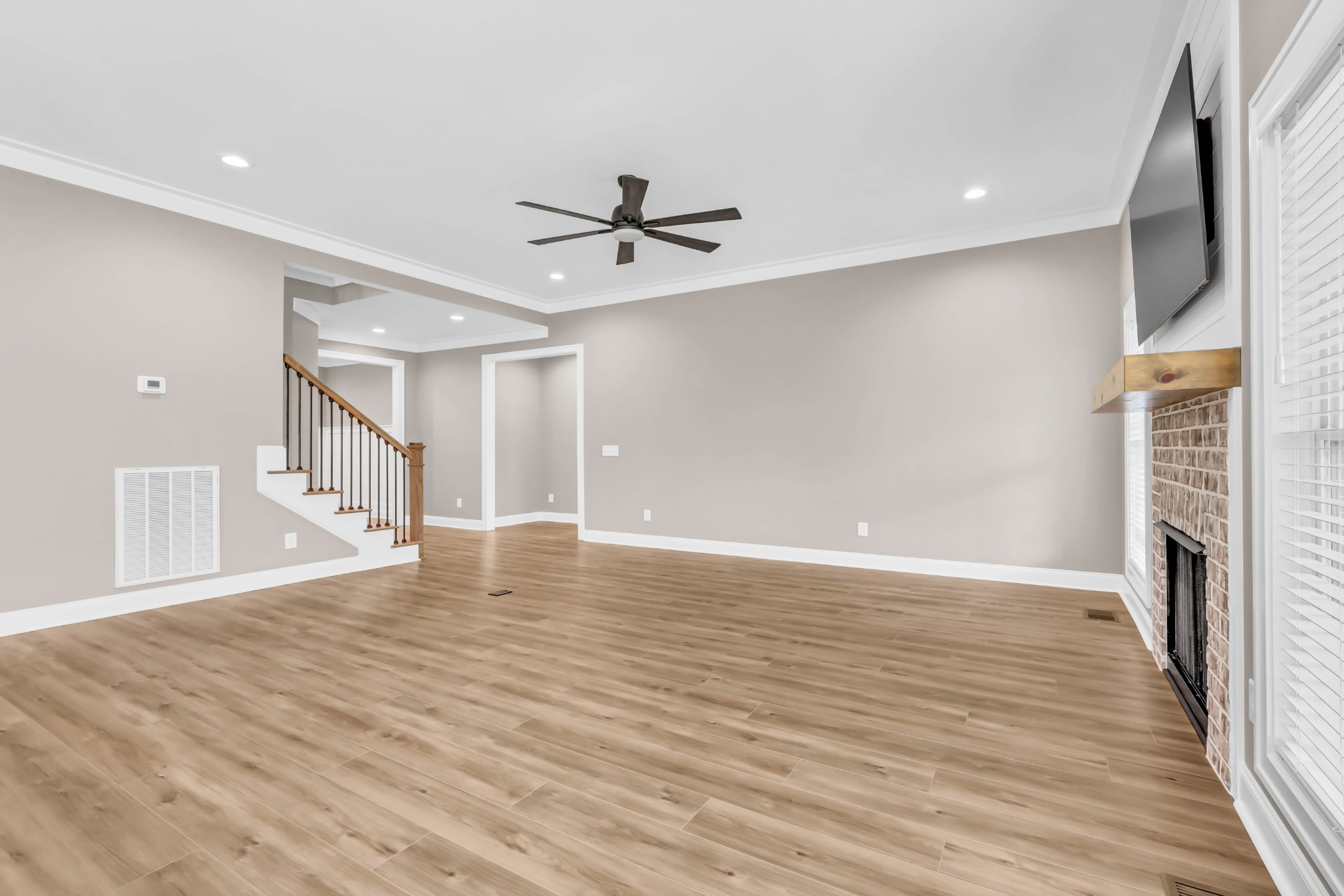282 Martha Morgan Way Cunningham, TN 37052 - Photo 8 of 36 a view of an empty room with wooden floor and a ceiling fan