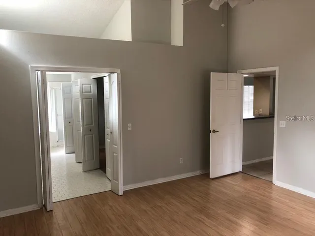an empty room with wooden floor and windows