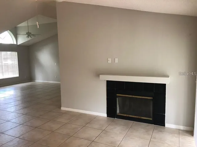 an empty room with a fireplace and window