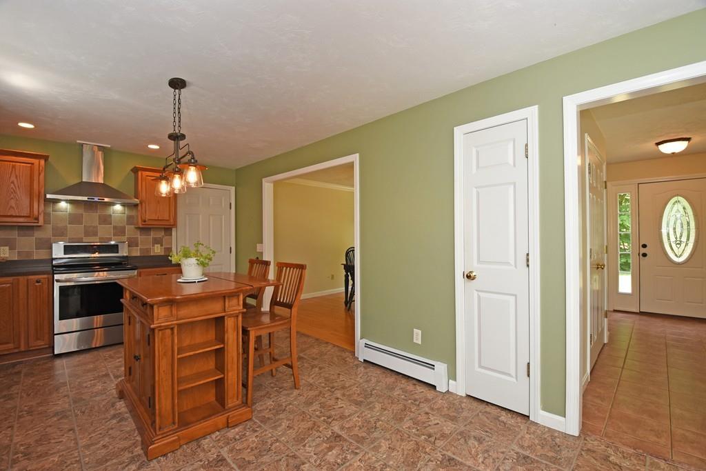 253 Pommogussett Road Rutland, MA 01543 - Photo 3 of 25 a kitchen with kitchen island granite countertop a stove a sink a dining table and chairs