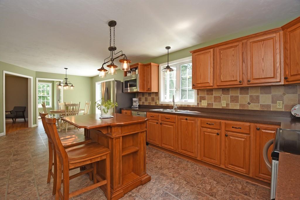 253 Pommogussett Road Rutland, MA 01543 - Photo 4 of 25 a dining hall with stainless steel appliances granite countertop a kitchen island a stove a table and chairs