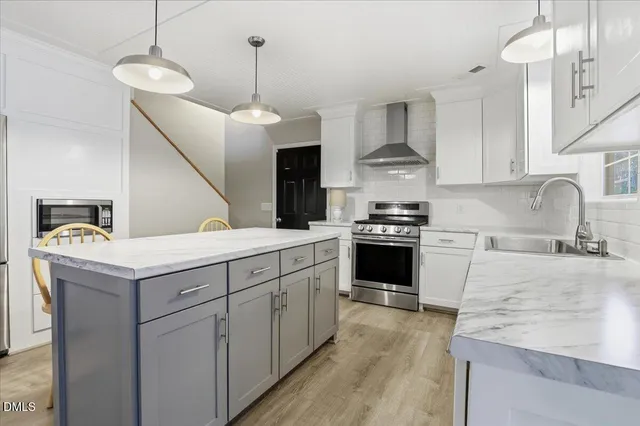 a kitchen with granite countertop a sink stainless steel appliances and white cabinets