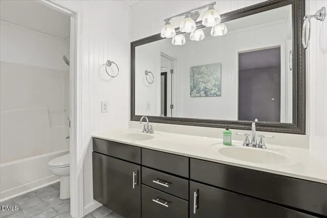 a bathroom with a double vanity sink a toilet and a mirror