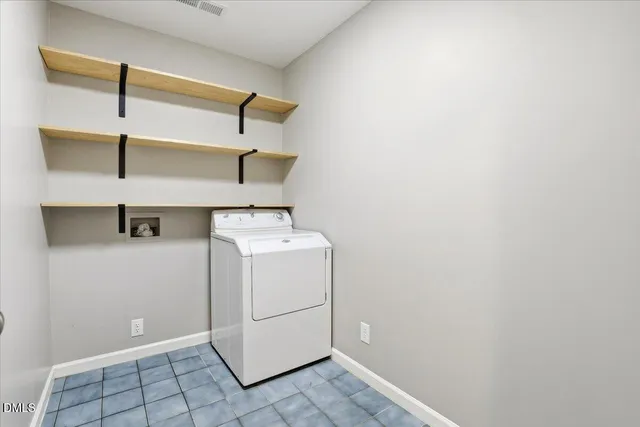a utility room with cabinets and washer