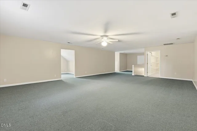 a view of an empty room with a ceiling fan