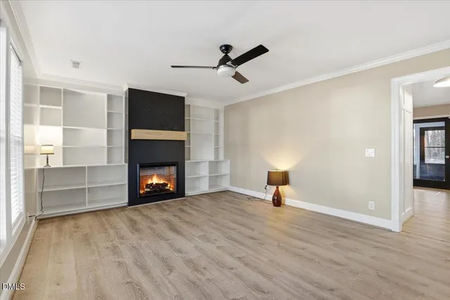 a view of empty room with wooden floor and fireplace