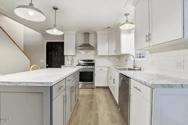 a kitchen with granite countertop stainless steel appliances a sink a stove and cabinets