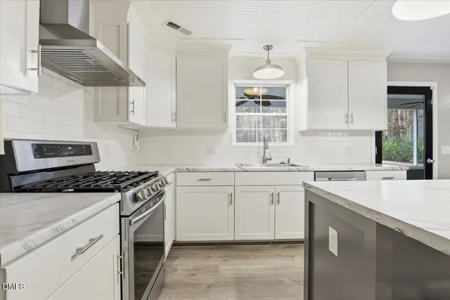 a kitchen with cabinets appliances a sink and a window