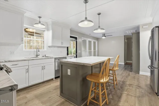 a kitchen that has a cabinets counter space dining table and a chandelier