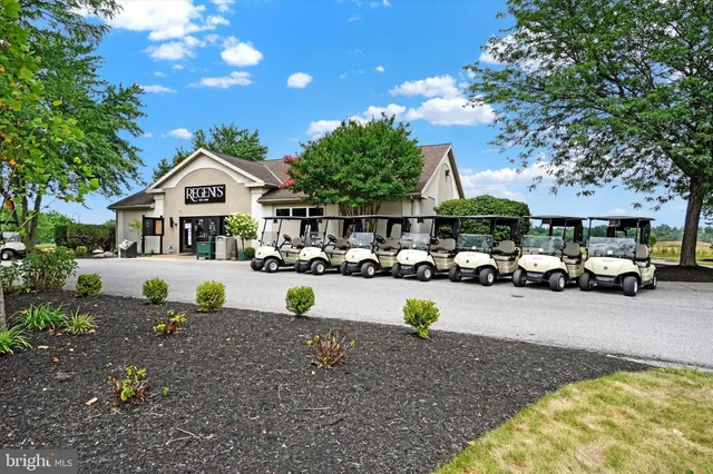a view of a white house with a swimming pool table and chairs