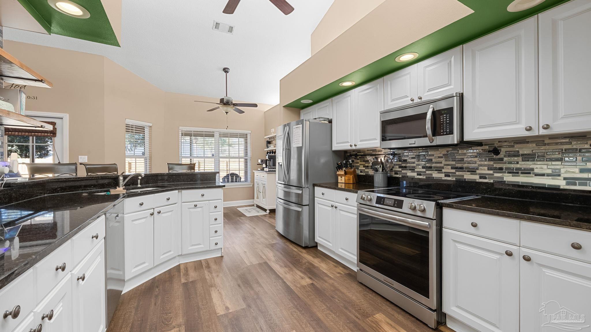 10305 Nightwind Circle Cantonment, FL 32533 - Photo 26 of 46 SS range, microwave, and mosaic backsplash.