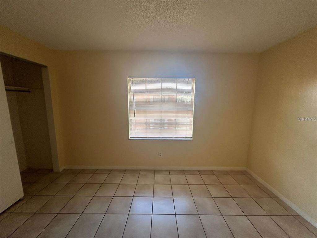 1627 West Oak Ridge Road, Unit D Orlando, FL 32809 - Photo 12 of 17 an empty room with a white cabinet and a window