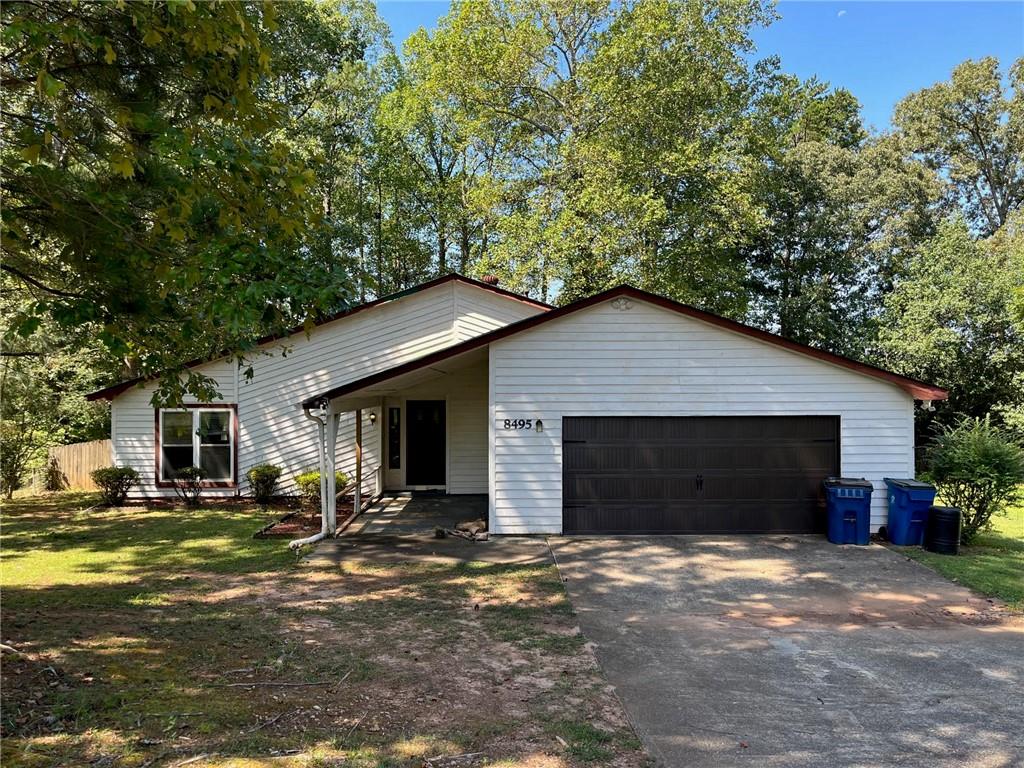 a front view of house with yard and trees in the background